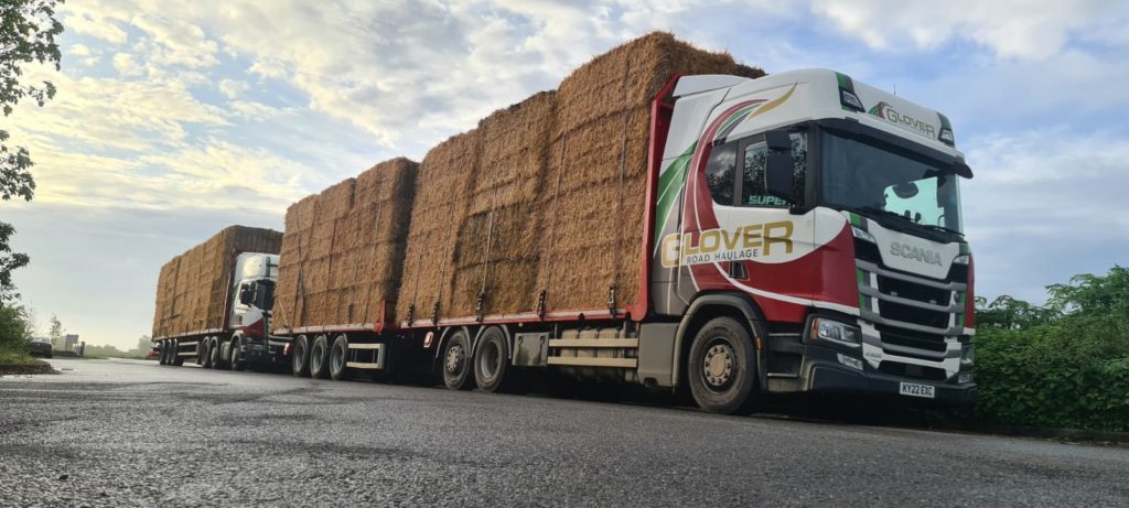 Two Glover lorries fully loaded with hay blocks stack on the top of each other