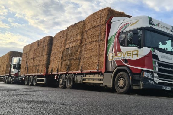 Two Glover lorries fully loaded with hay blocks stack on the top of each other